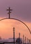 Metallic Christian cross and a row of electric poles