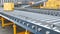 Metallic conveyors with boxes are stretching far away, stack of boxes is near,