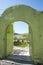 Metallic door painted green as well as the stone wall that supports it. Muslim architecture with entrance to a patio