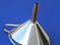 Metallic funnel in front of a blue background with reflections in silver turquoise