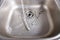 Metallic kitchen sink with water