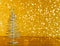 Metallic modern christmas tree on wood table on golden tint light bokeh background