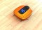 Metallic orange robotic vacuum cleaner moving on flooring