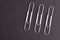 Metallic Paper clips isolated on black background, three,