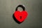 Metallic red heart shaped lock on a black background with copy space