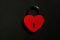 Metallic red heart shaped lock on a black background with copy space