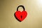 Metallic red heart shaped lock on a golden background