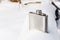 Metallic shiny flask for alcohol in the snow. Nature, winter, rest