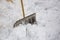 Metallic snow shovel stuck in the snow