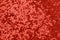 Metallic star shaped confetti on festive red background.