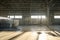 Metallic supplies and equipment lying on sunlit floor of spacious warehouse