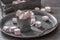 Metallic vintage tray, surface and cup with pink and white marshmallows inside the cup and scattered around the tray as