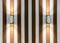 Metallic wall lights with double sided glow on the wall with gold stripes