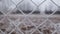 Metallic wire fence with hoarfrost on barren cold winter landscape