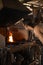 Metalworker stoking the fire in a forge to work steel.