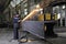 Metalworkers polishing welds metal structures, producing fountain of sparks.