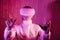 Metaverse concept in magenta color. Color of the 2023 year. Woman in vr glasses on matrix code background, playing video