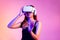 Metaverse concept young asian woman in black tank top wearing white vr headset hand touching watching and playing on the pink