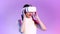 Metaverse concept, young asian woman wearing white vr headset touching isolated purple neon background.