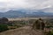 Meteora - Cross with bell on top of rock Aghio Pnevma (Holy Spirit). Panoramic view on valley between village of Kastraki