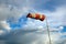 Meteorology wind bag for marine navigation. Red and white windsock blows against a blue sky