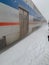 Metra train pulls into station during snowstorm with blowing snowdrifts