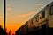 Metra train travels into the sunset at the end of a late winter day.