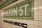 Metro station sign of Fulton street made of small green tiles in New York City