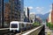 A Metro train travel on elevated rails of Wenhu Line of Taipei MRT System by office towers under blue clear sky