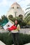 Mexican adult woman shows the flag of Mexico with pride of her culture and tradition