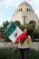 Mexican adult woman shows the flag of Mexico with pride of her culture and tradition