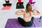 Mexican adult woman sitting touching her shoulders during yoga class in Latin America