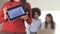 Mexican American Business woman displaying graph on tablet with coworkers in background