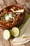 Mexican Birria de Res served with lime and tortilla closeup in a bowl. vertical