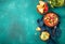 Mexican black bean soup with tomato, avocado and totopos. Blue background, top view