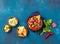 Mexican black bean soup with tomato, avocado and totopos. Blue background, top view