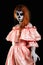 Mexican body art. God of death. Redhead girl in peachy dress. Woman monster. Creative dark make-up.