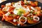 Mexican breakfast: chilaquiles with egg and chicken close-up. ho
