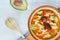Mexican caldo tlalpeÃ±o Traditional soup with chipotle chile, avocado, chickpea, chicken, cheese and carrots