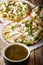 Mexican Chalupas with cheese and chicken meat and sauce salsa verde closeup vertical