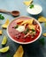 Mexican Chilli bean soup with yogurt, cheese, lime and tortilla chips in white bowl