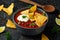 Mexican Chilli bean soup with yogurt, cheese and tortilla chips in black bowl
