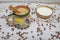 Mexican coffee with cinnamon in cup with Mexican decoration on white wooden table with organic coffee grains and natural bowl with