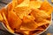 Mexican corn, tortilla cheese chips in a white cup on wooden table