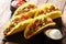 Mexican fast food tacos with chopped beef, cheese and vegetables served with sauces close-up on a slate boarde. horizontal
