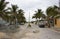 Mexican fishing village street during the rainy season with cars parked along the sides and bag of garbage in the middle of the st