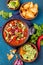 Mexican food concept background with chile black bean soup, guacamole and nachos totopos. Top view