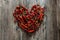 Mexican food. dried red hot chilli pepper in shape of heart on wooden background. spicy taste