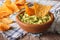 Mexican food: guacamole sauce and nachos closeup in a bowl. hori