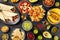 Mexican food, many dishes of the cuisine of Mexico, flat lay, shot from above on a black background. Nachos, tequila
